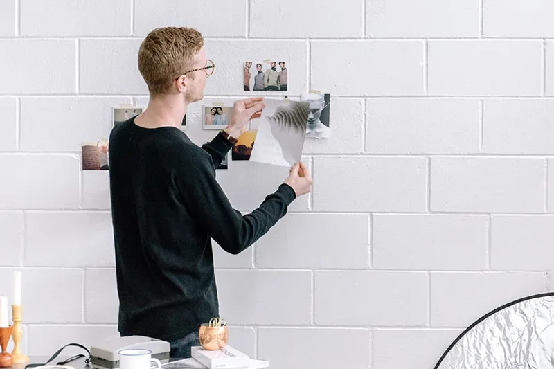 young professional hanging pictures on a wall