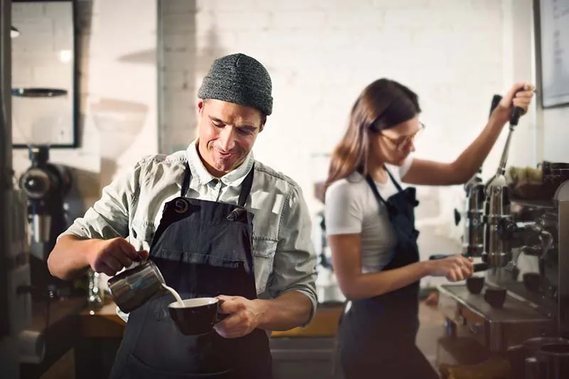 A man and a woman making a latte 