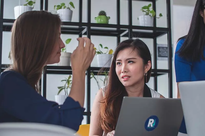 two customer success manager women working on their laptops