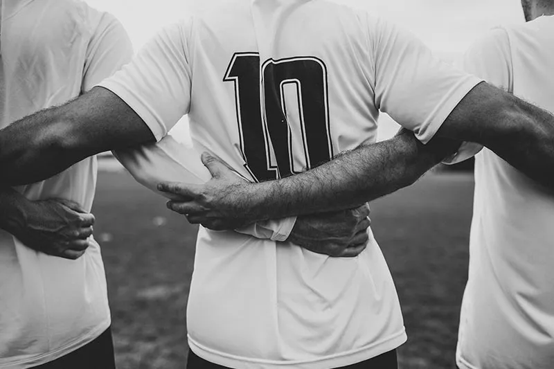 men hugging after playing baseball 