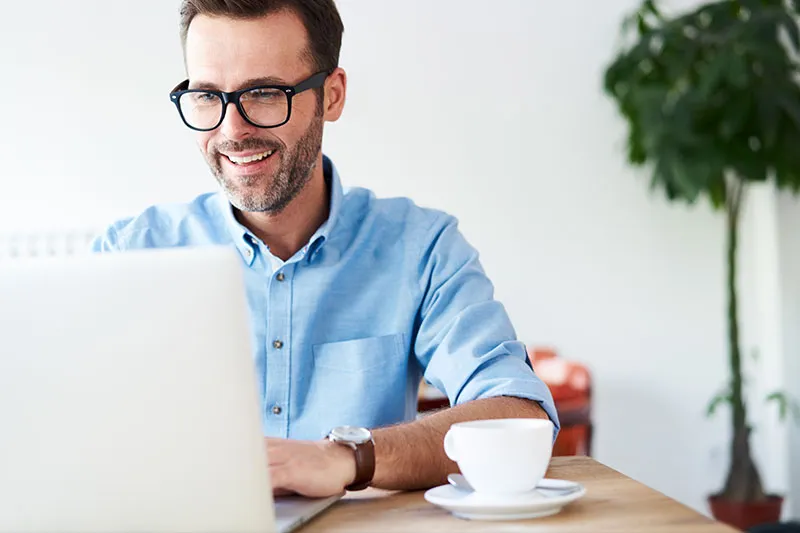 Man working at his computer and having coffee