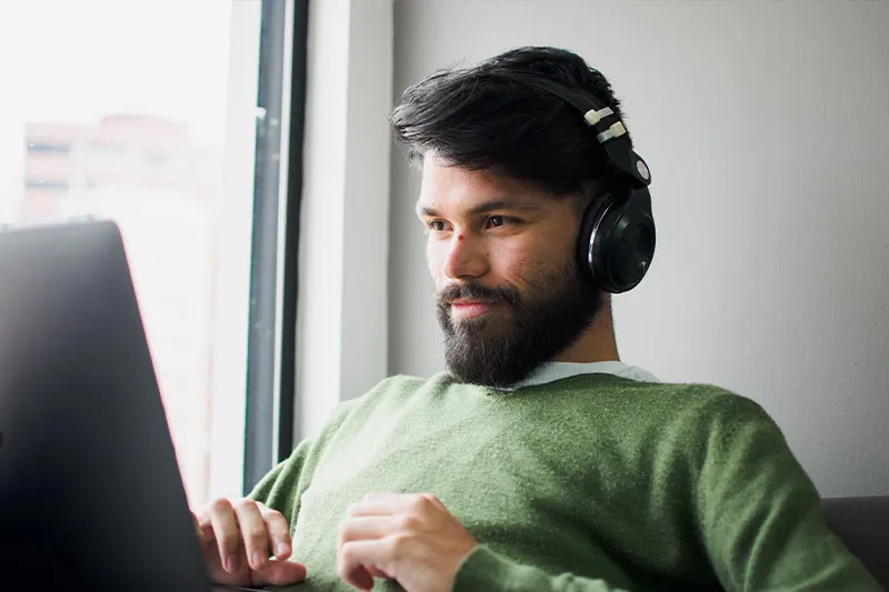 man working on laptop with headphones on