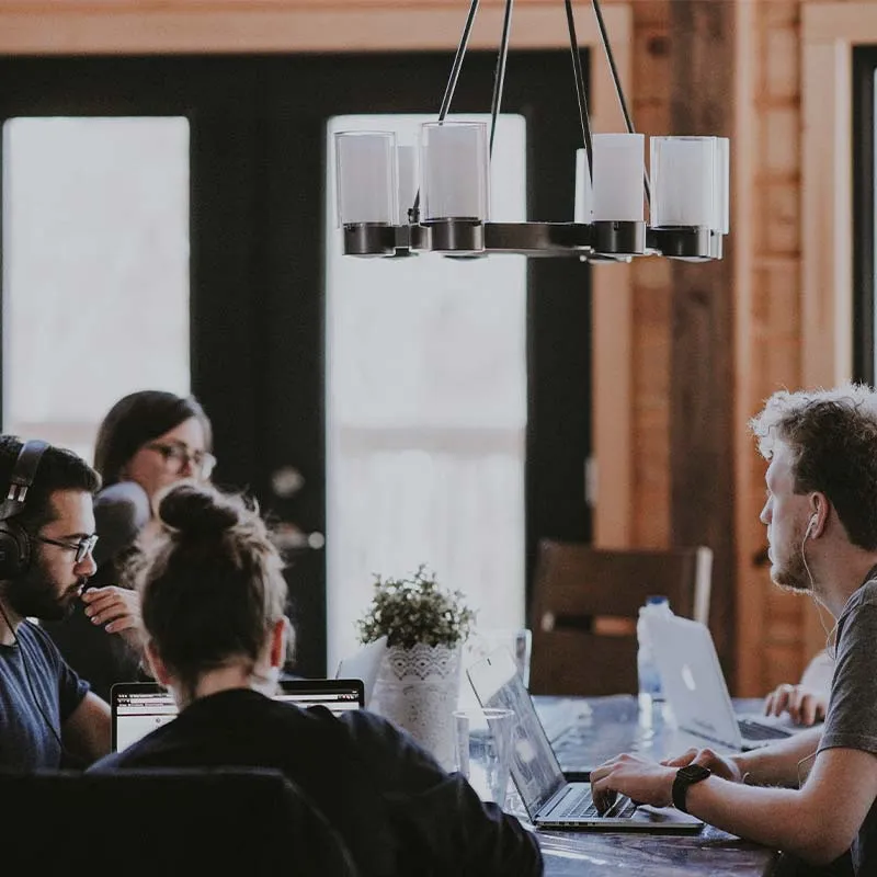 people sitting at a table working on laptops