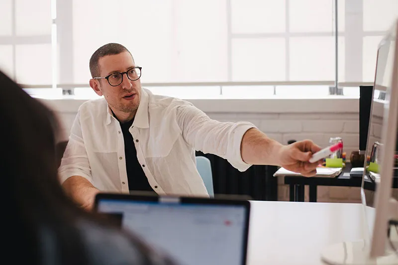 man in a meeting pointing at something