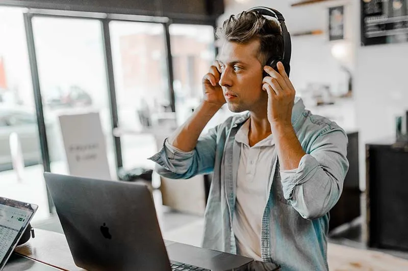 man using headphones and laptop