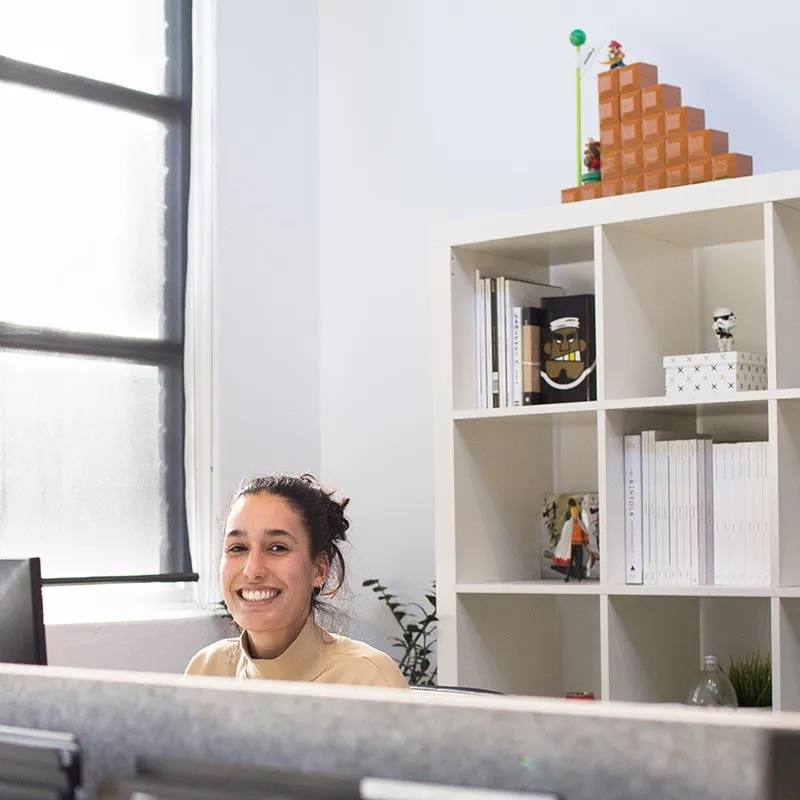 an employee at her desk smiling