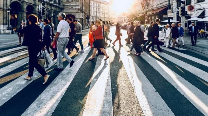 people crossing the street on a zebra crossing