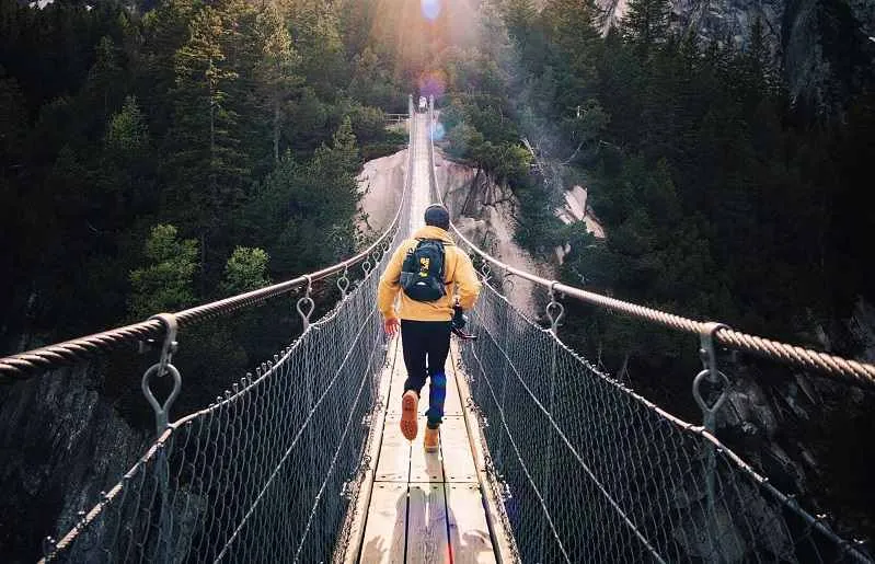 man crossing a bridge