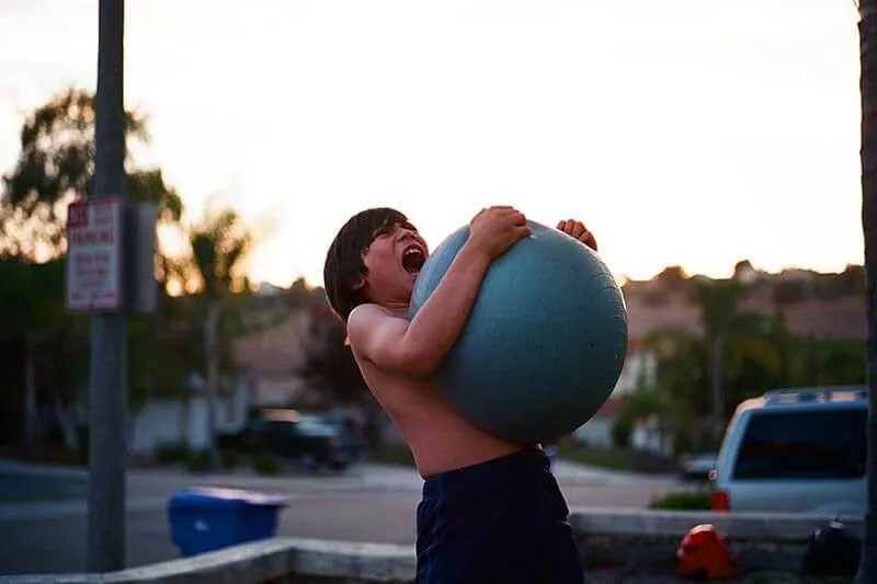 a young boy playing with a gym ball