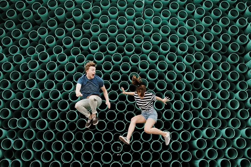 Young girl and a boy jumping on a trampoline