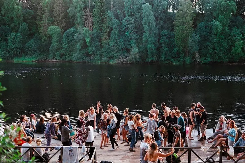 a group of young people interacting with each other at a lake