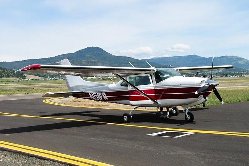 a red and white jet and mountains