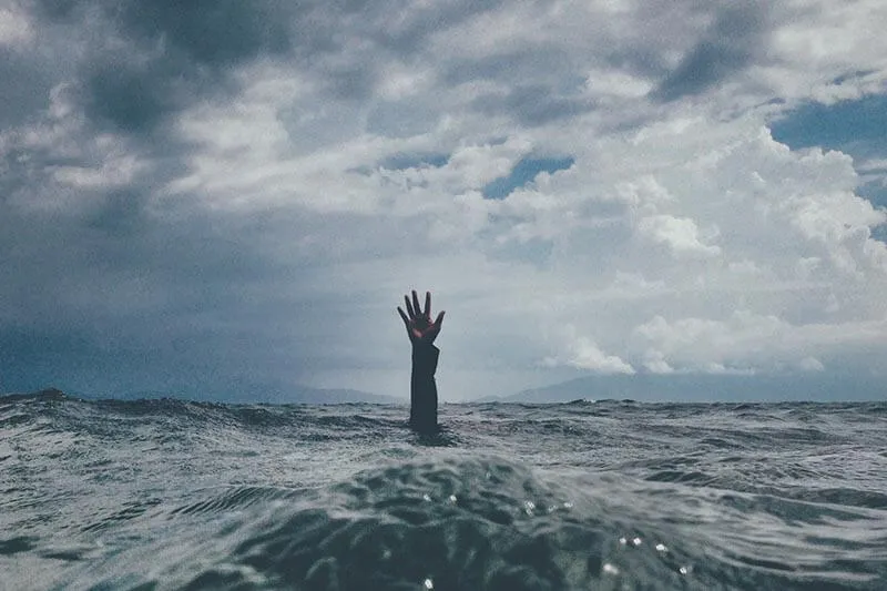 hand in the water of a man drowning into the sea