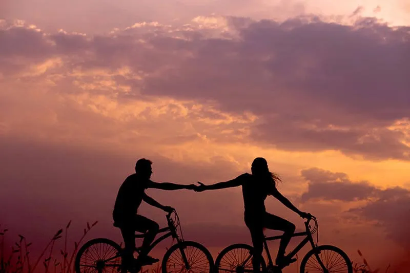 silhouette of a couple cycling together