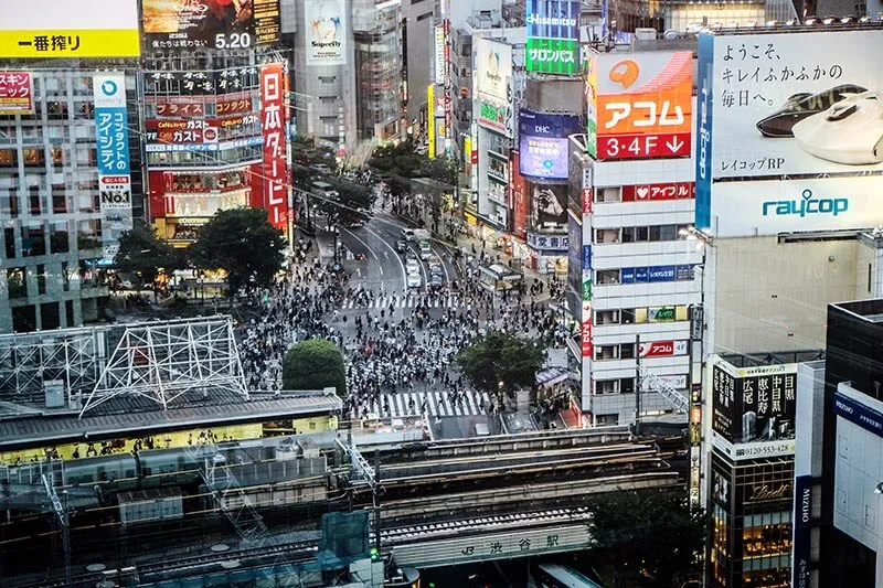 center of a busy city with people crossing streets