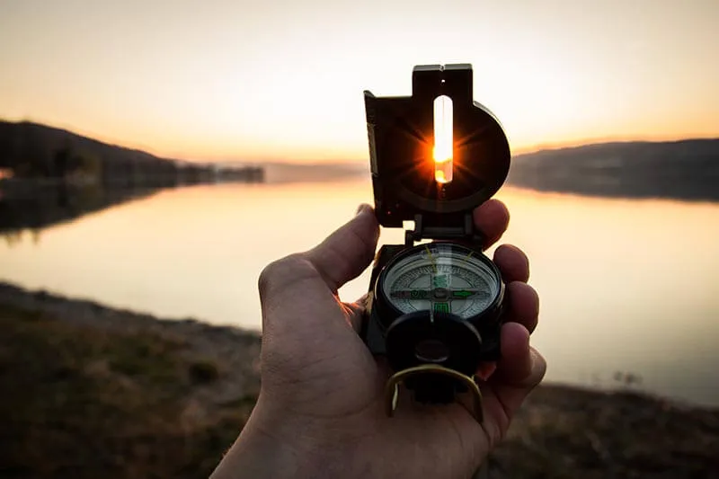 a man with a compass in the mountains