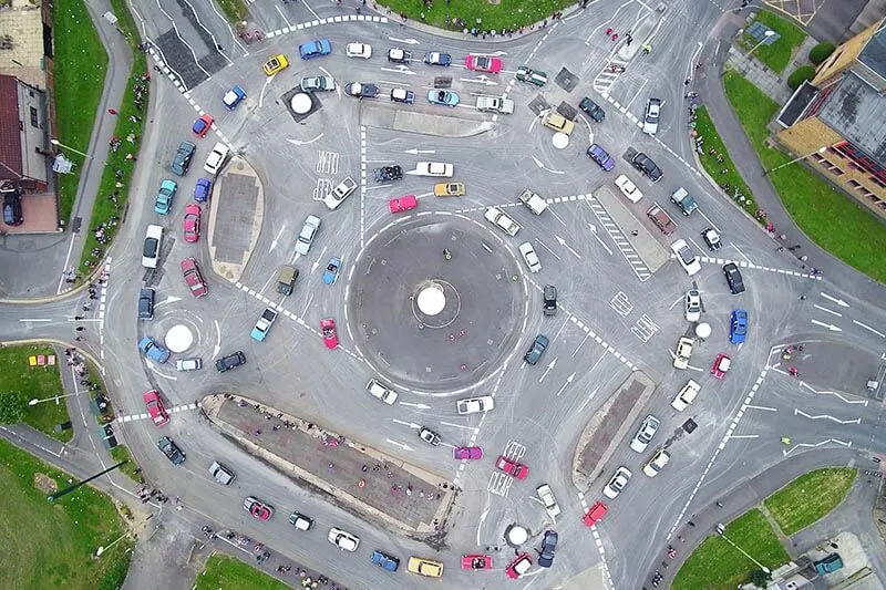 a drone photo of a traffic jam at a round square