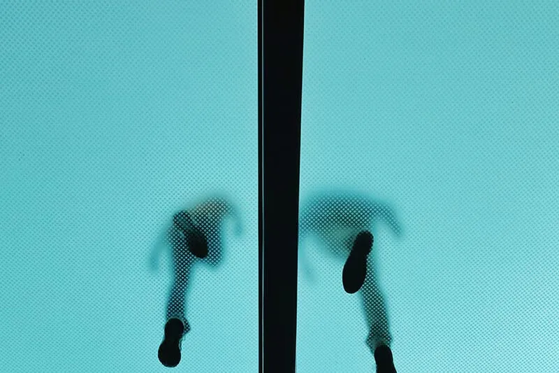 two people walking on a glass floor viewed from below