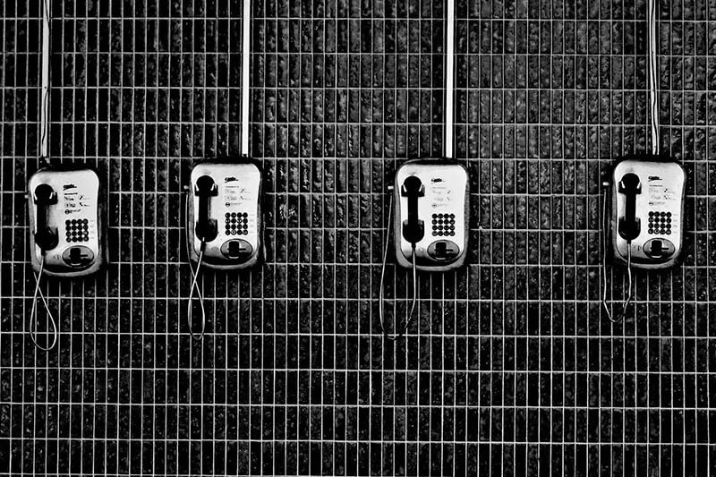 vintage chrome telephones on a steal cage wall