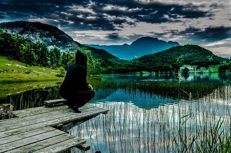 a man sitting on a wooden deck on the country side