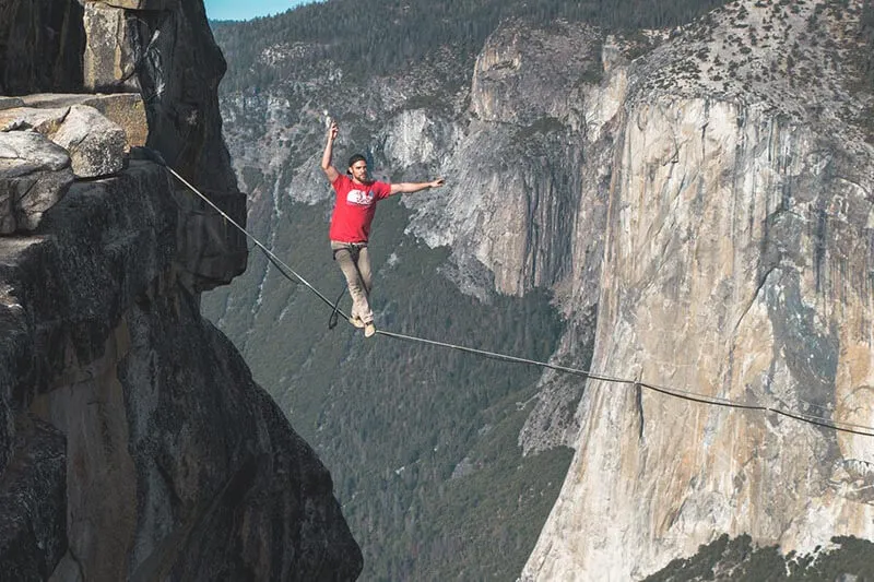 a man walking and balancing on a rope