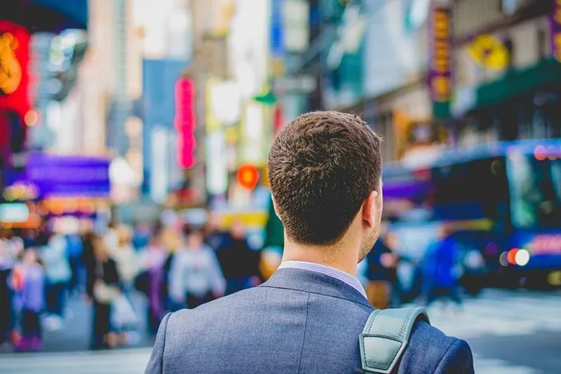 a man in a blue suit walking on the road