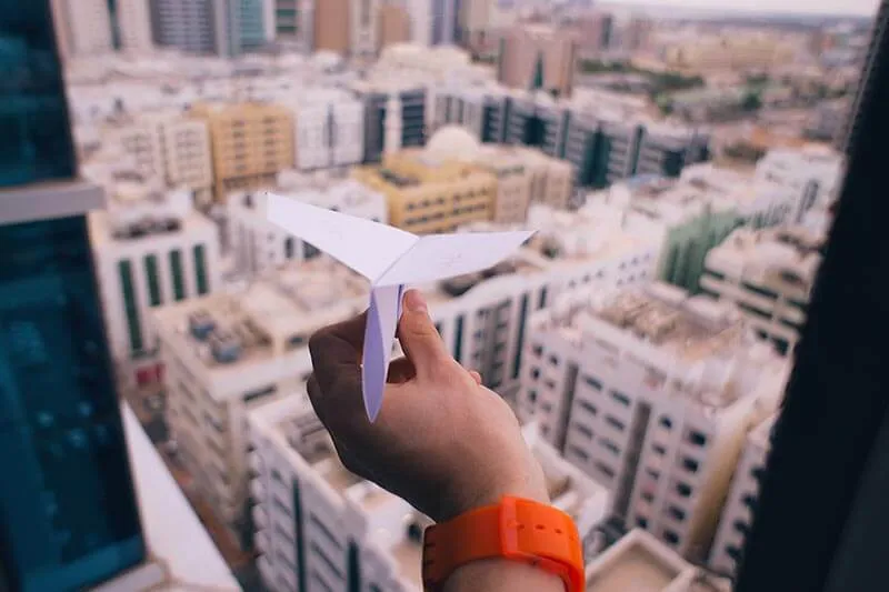 paper airplane outside of a window