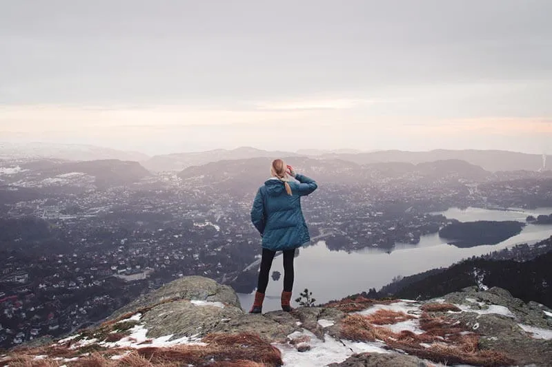 a girl on the top of a mountain celebrating success