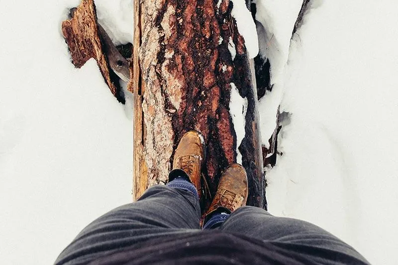 a man walking on a wooden log