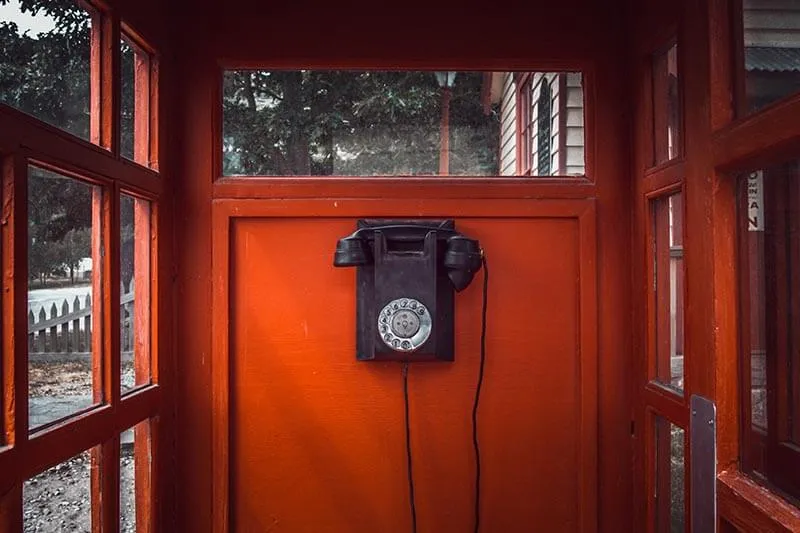 a vintage phone in a red phone booth
