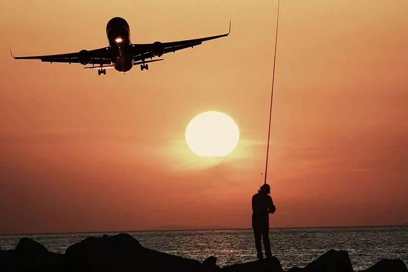 silhouette of a person and a plane on the beach