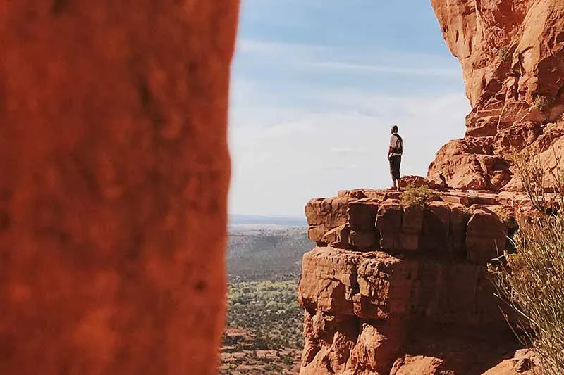 a man standing on the edge of a cliff alone