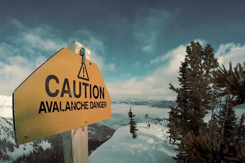 caution sign pointing out the risk of avalanche in the mountains