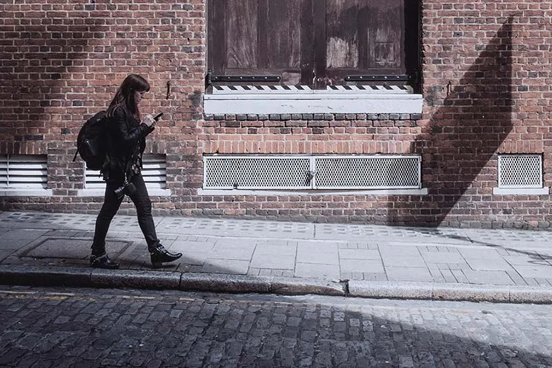 a girl walking on the street with her smartphone