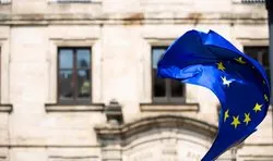 EU flag blowing in wind before a building