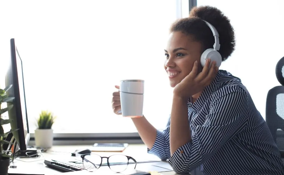 woman sitting in front of computer drinking coffee and attending an online elearning course