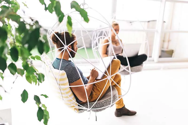 young person sitting in a modern chair in an office space