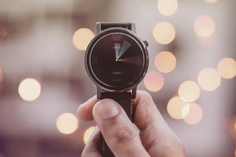 a watch in the hand with blurred background bokeh