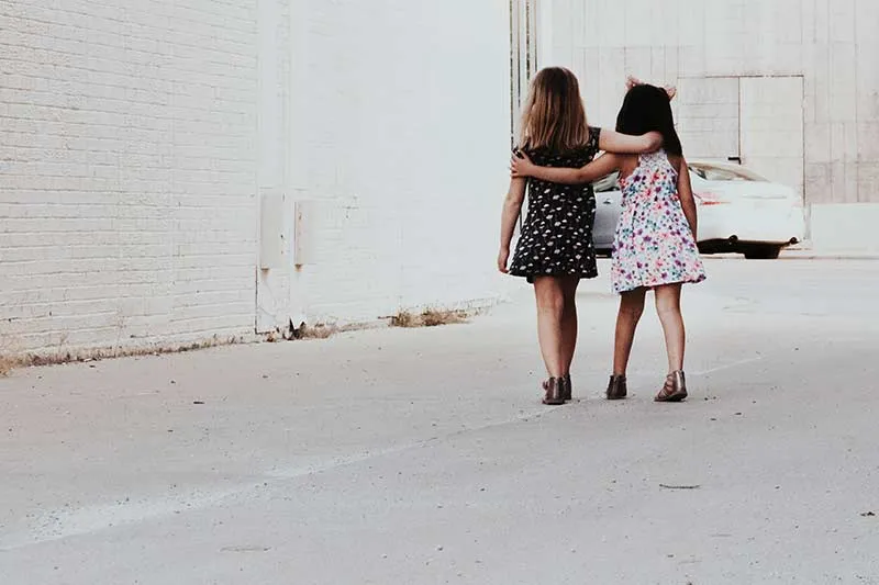 Two young girls walking on the street